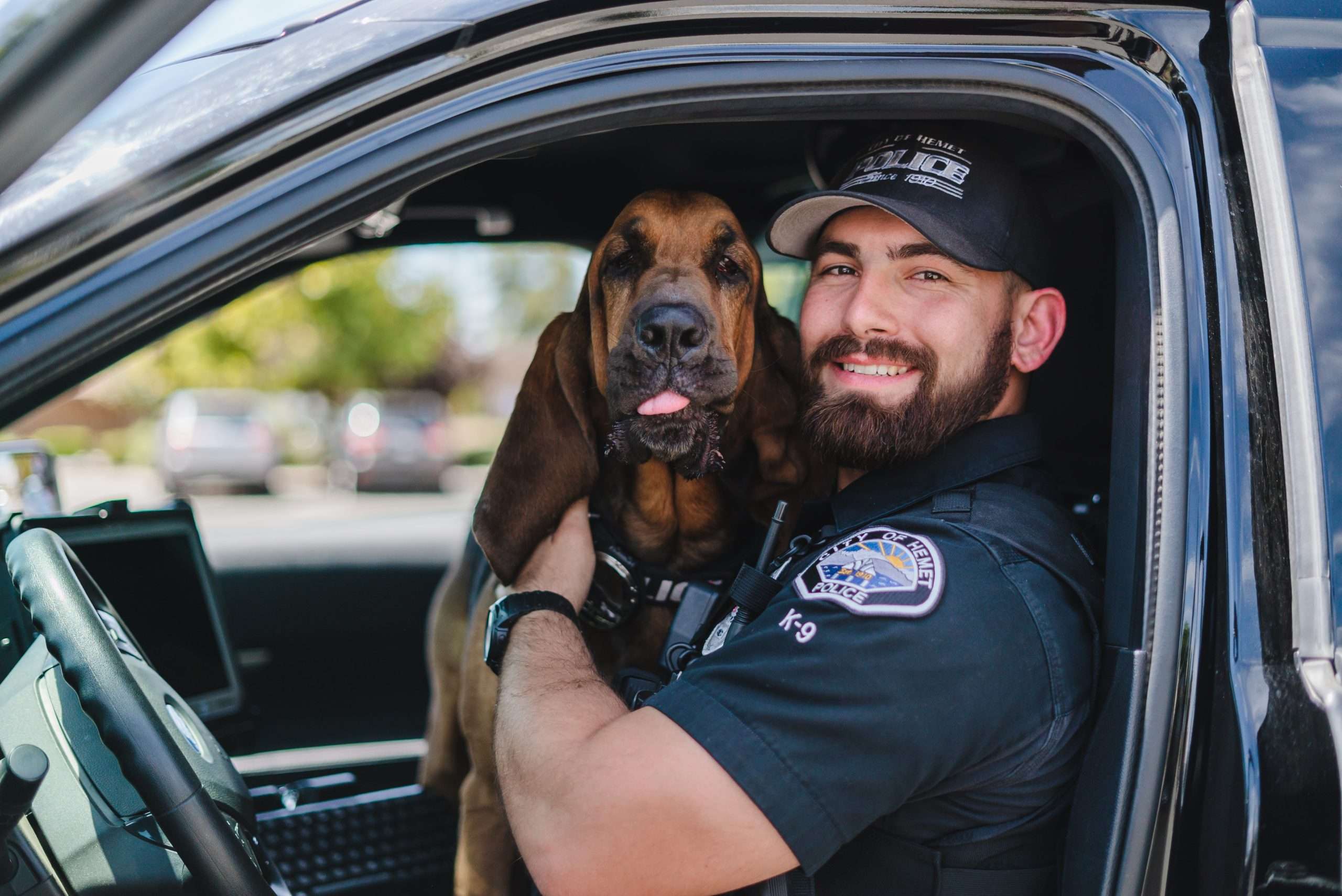 A Hemet Police Officer Bloodhound poses for a photo with its handling officer