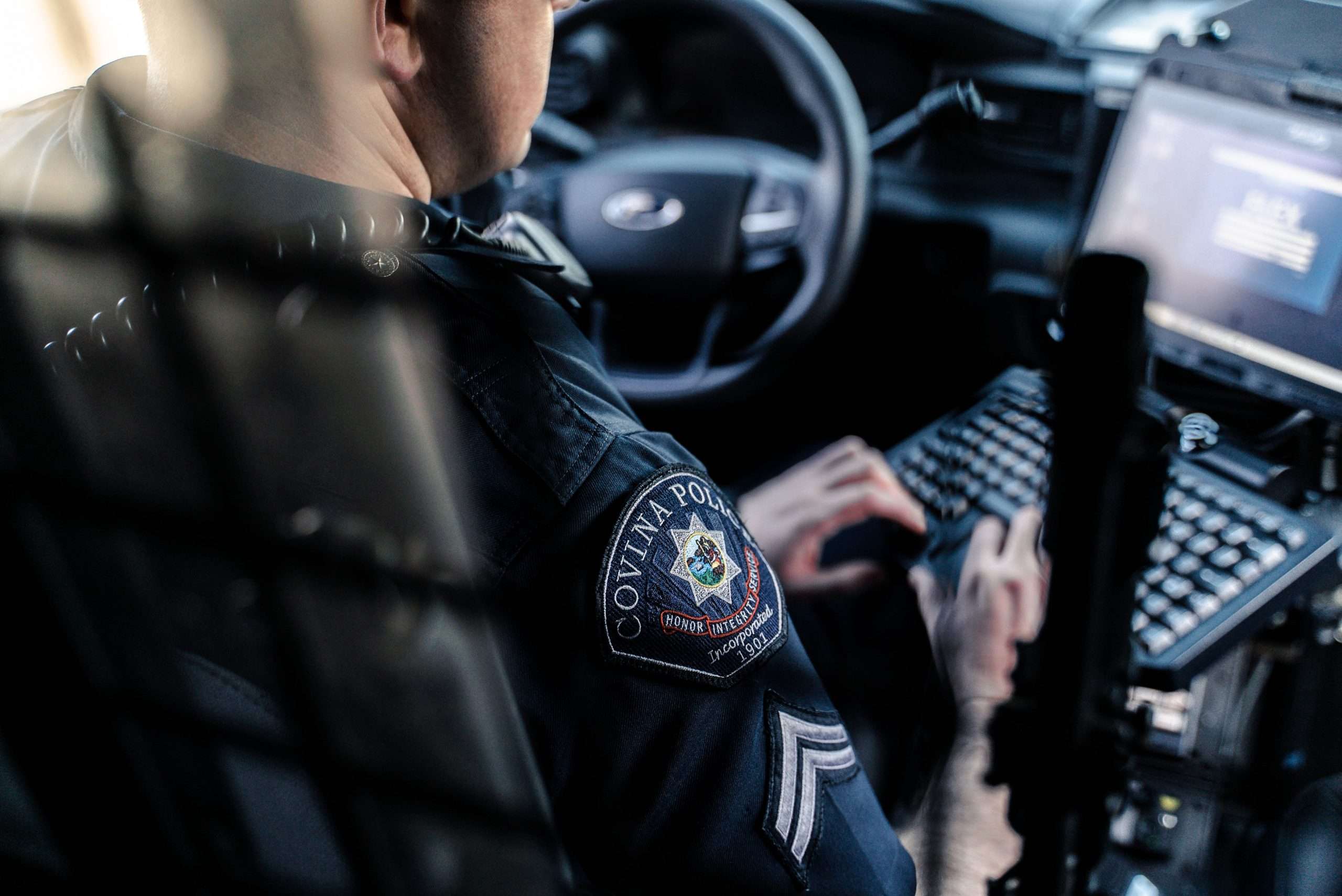 A Covina Police Officer uses his mobile computer in his patrol vehicle