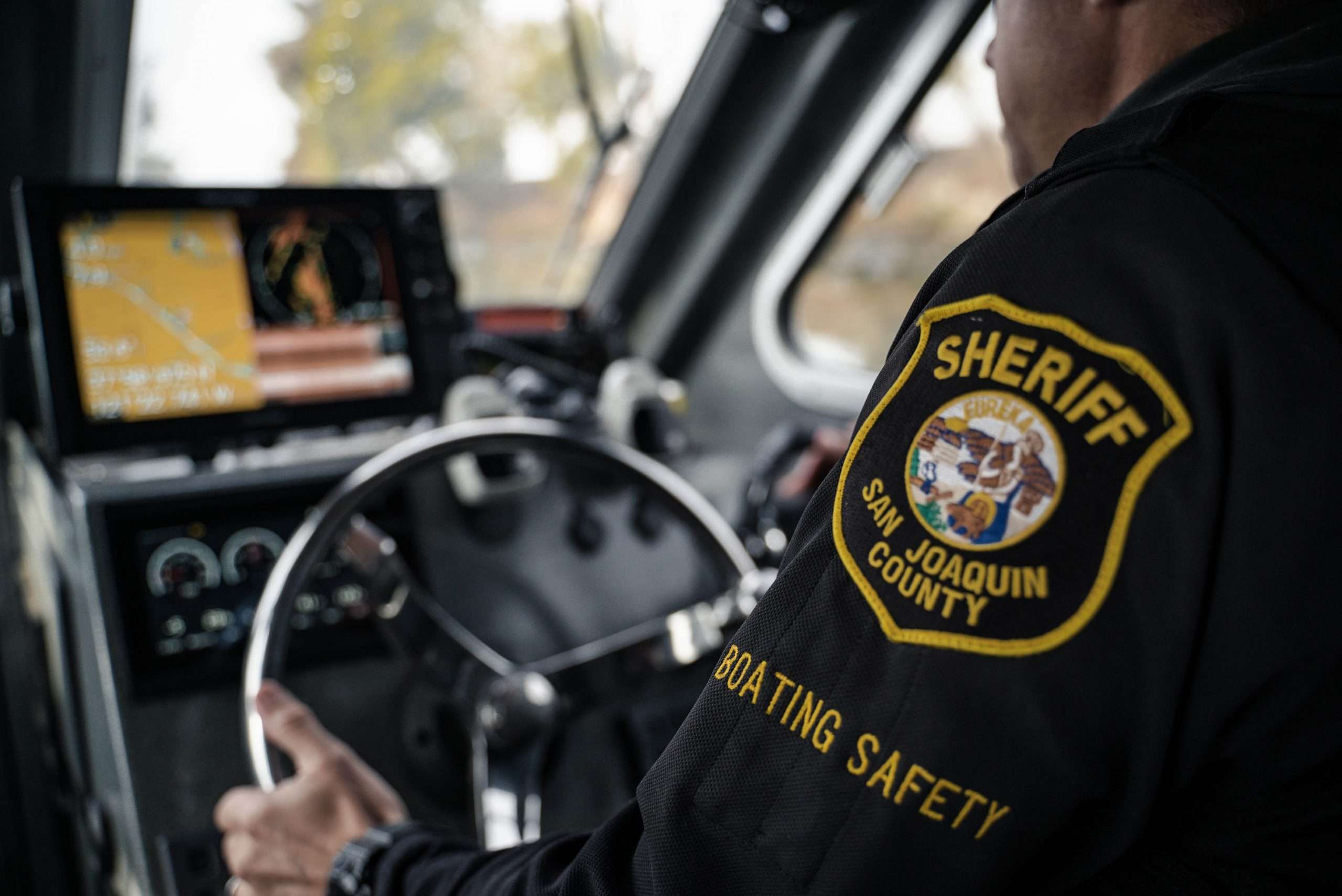A San Joaquin County Sheriff's Deputy steers a patrol boat